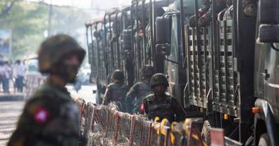 Reuters - FILE - Soldiers stand next to military vehicles in Yangon, Myanmar, February 15, 2021. The main underground group coordinating resistance to Myanmar's military government called for a nationwide uprising Sep. 6, 2021