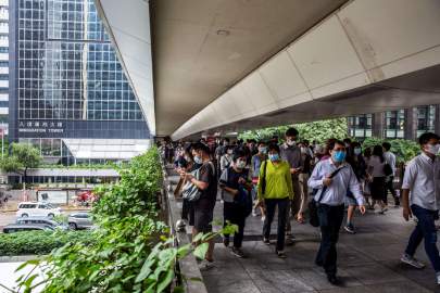 © Isaac Lawrence/Getty Images China's Foreign Ministry called President Joe Biden's offer to provide refuge for Hong Kong residents "shameless political manipulation." Pedestrians walk on a footbridge in the Wanchai district of Hong Kong on August 6, 2021.