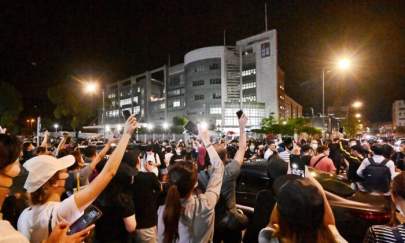 Supporters of Hong Kong newspaper Apple Daily wave their cellphone lights outside of the paper’s headquarters in Hong Kong on June 23, 2021. (Sung Pi-lung/The Epoch Times)