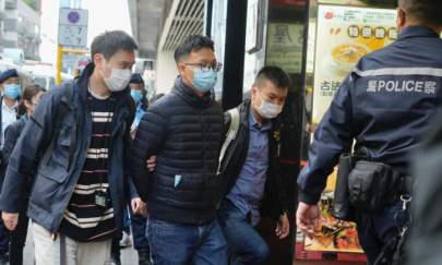 Editor of "Stand News" Patrick Lam, second from left, is arrested by police officers in Hong Kong on Dec. 29, 2021. (Vincent Yu/AP Photo)