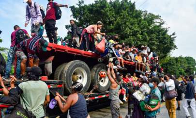 Migrants who were heading in a caravan to the United States get off a truck in Nuevo Morelos, Jesus Carranza municipality, Veracruz state, Mexico, on Nov. 17, 2021. (Claudio Cruz/AFP via Getty Images)