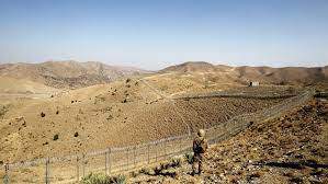 FILE - A soldier stands guard along the border fence outside the Kitton outpost on the border with Afghanistan in North Waziristan, Pakistan Oct. 18, 2017.