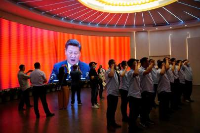 A group recites the party oath in front of a screen showing Mr. Xi in Shanghai, June 4. PHOTO: ALY SONG/REUTERS