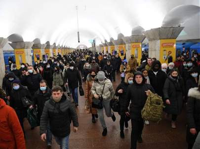 People, some carrying bags and suitcases, walk at a metro station in Kyiv early on February 24, 2022. – Russian President Vladimir Putin announced a military operation in Ukraine on Thursday with explosions heard soon after across the country and its foreign minister warning a “full-scale invasion” was underway. (Photo by DANIEL LEAL/AFP via Getty Images)