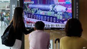 People watch a TV screen showing a file image of a North Korean missile in a military parade during a news program at the Seoul Railway Station in Seoul, South Korea, Aug. 30, 2021. 