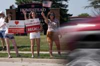 Supporters to recall the entire Mequon-Thiensville School District board wave at cars outside Homestead High School Monday, Aug. 23, 2021, in Mequon, Wis. A loose network of conservative groups with ties to major Republican donors and party-aligned think tanks is quietly lending firepower to local activists engaged in the culture war fights in schools across the country. (AP Photo/Morry Gash) THE ASSOCIATED PRESS