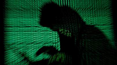 Kacper Pempel/Reuters, FILE A hooded man holds a laptop computer as cyber code is projected on him in this illustration picture taken on May 13, 2017.