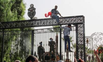 Tunisian soldiers guard the main entrance of the parliament as demonstrators gather outside the the gate in Tunis, Tunisia, on July 26, 2021. (Hedi Azouz/AP Photo)