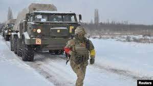 A service member of the Ukrainian Armed Forces runs near self-propelled multiple rocket launcher systems during drills in the Kherson region, Ukraine, in this handout picture released Feb. 1, 2022.